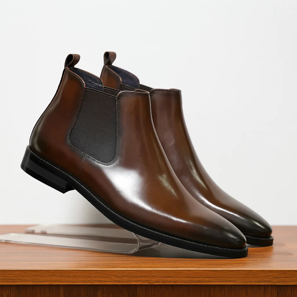 Men's Chelsea boots in brown with elasticated side panels and low heel on wooden surface