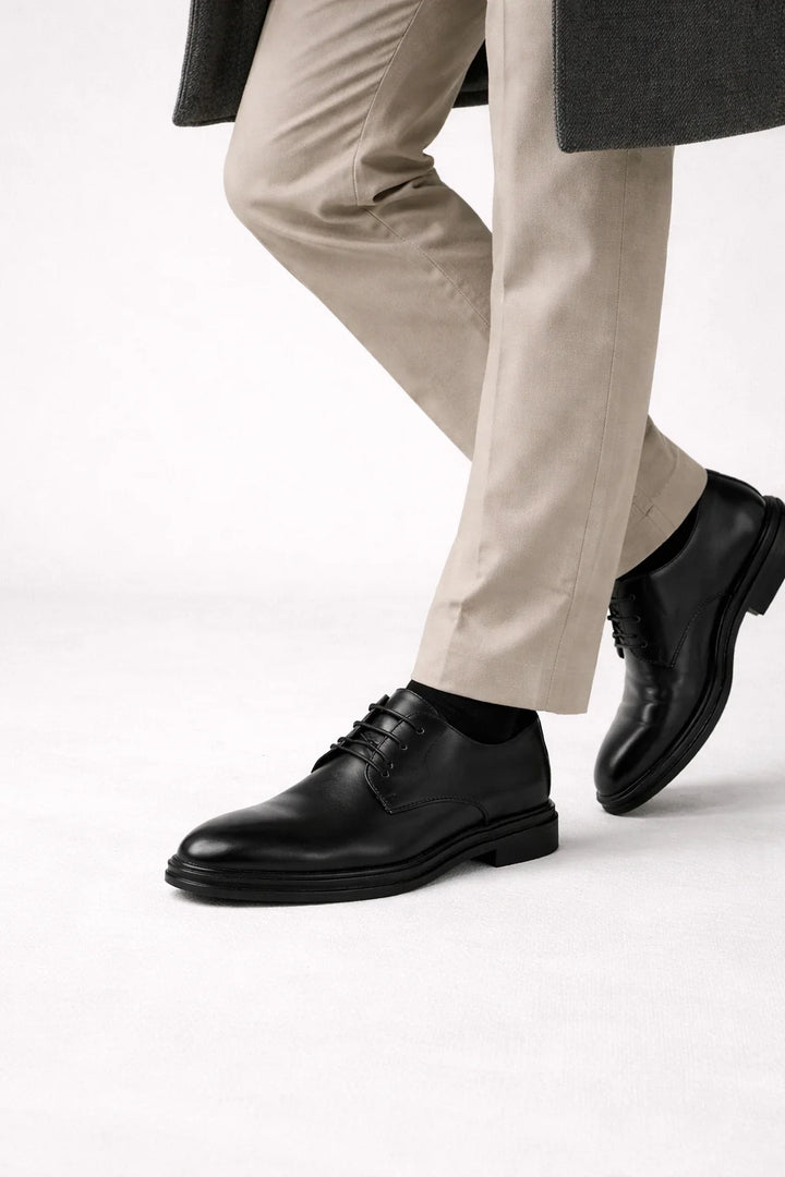 Close-up of men's derby shoe lace-up closure and rounded toe detail in charcoal finish