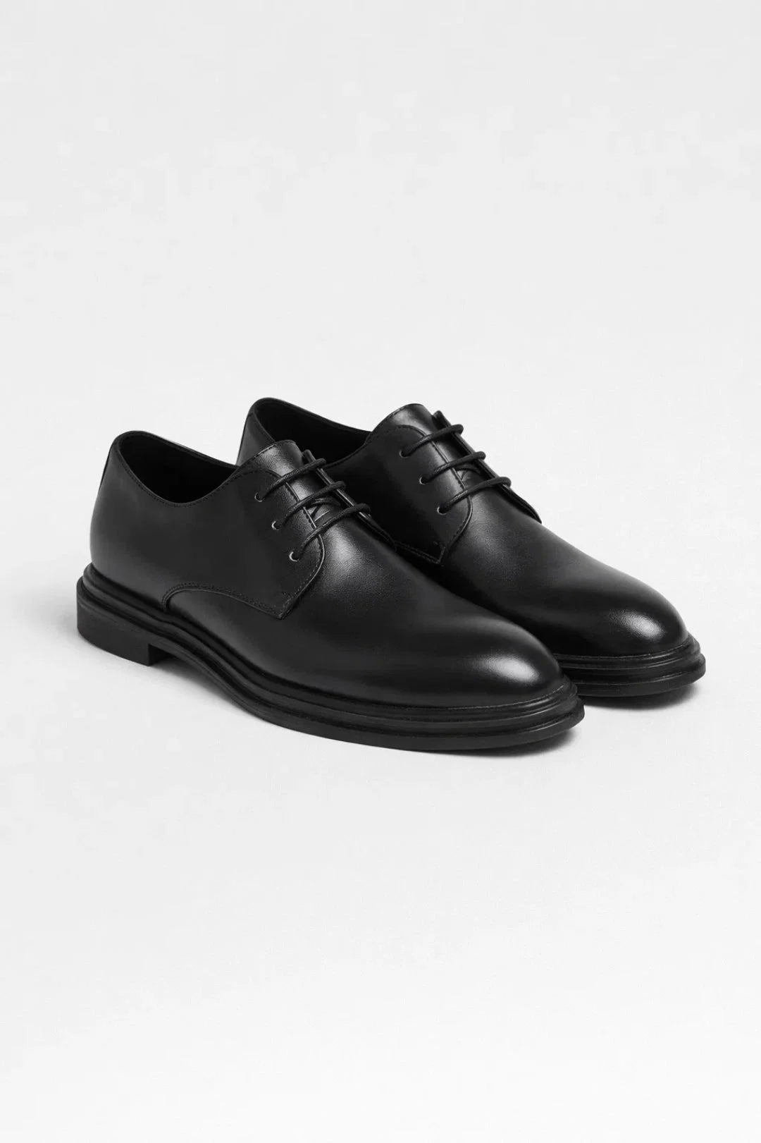 Men's derby shoes paired with navy trousers and black jumper for smart-casual office look