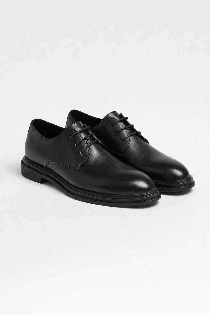 Men's derby shoes paired with navy trousers and black jumper for smart-casual office look