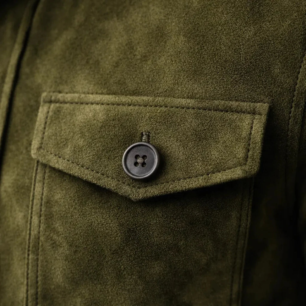 Detail of suede jacket chest pocket with button fastening and smooth finish