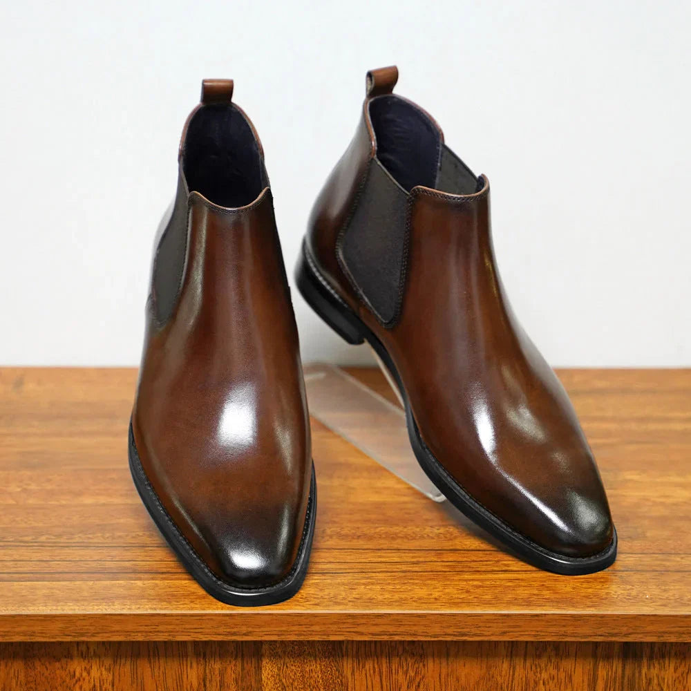 Close-up of men's Chelsea boots showing pull tabs and polished toe detail