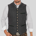 Men's charcoal Trachten waistcoat with standing collar, decorative button front, and contrast piping detail worn over patterned shirt