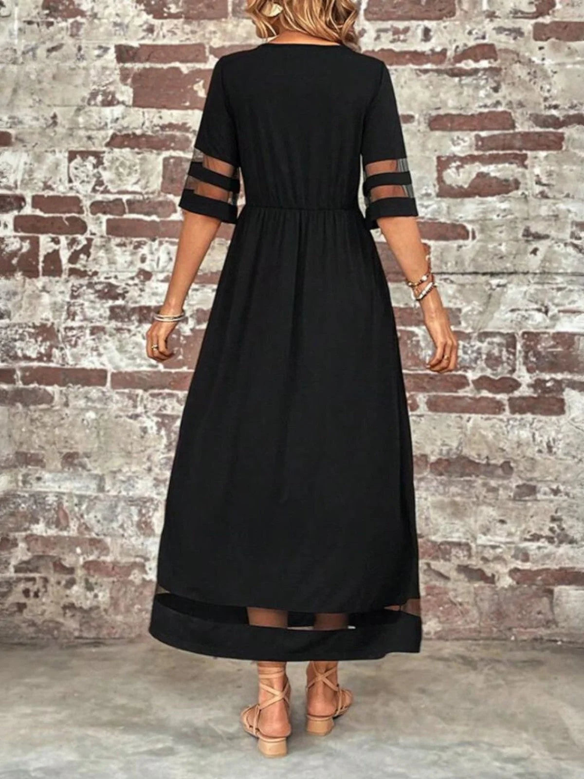Detail shot of the sheer mesh panel inserts on the sleeve and hem of the maxi dress