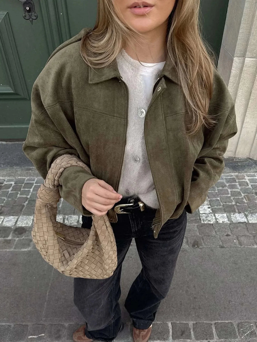 Side angle of women's collared bomber jacket displaying relaxed fit and elasticated cuffs