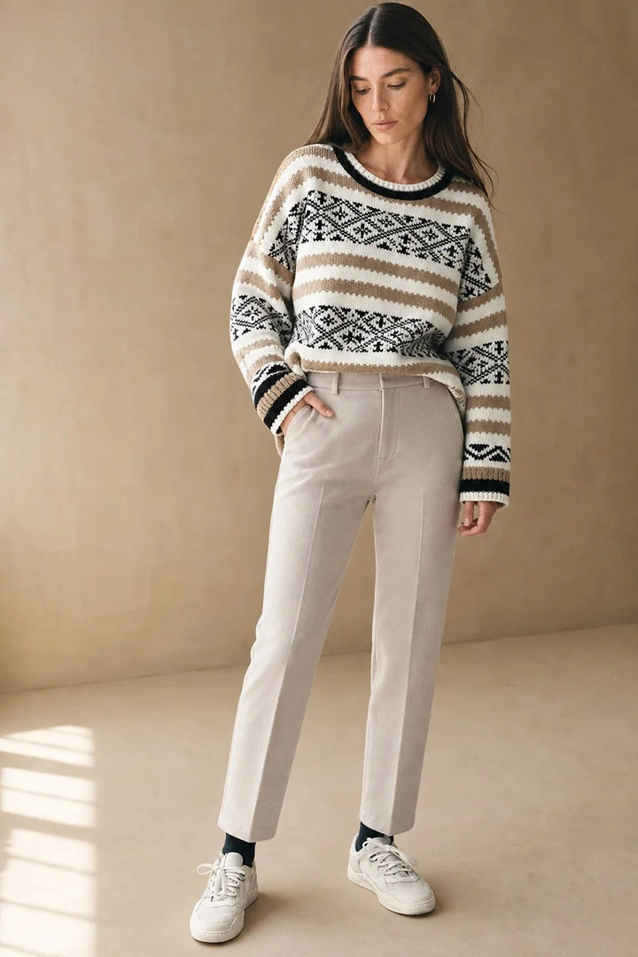 Side view of high-waist wool trousers with classic front pleats and zip-fly closure detail