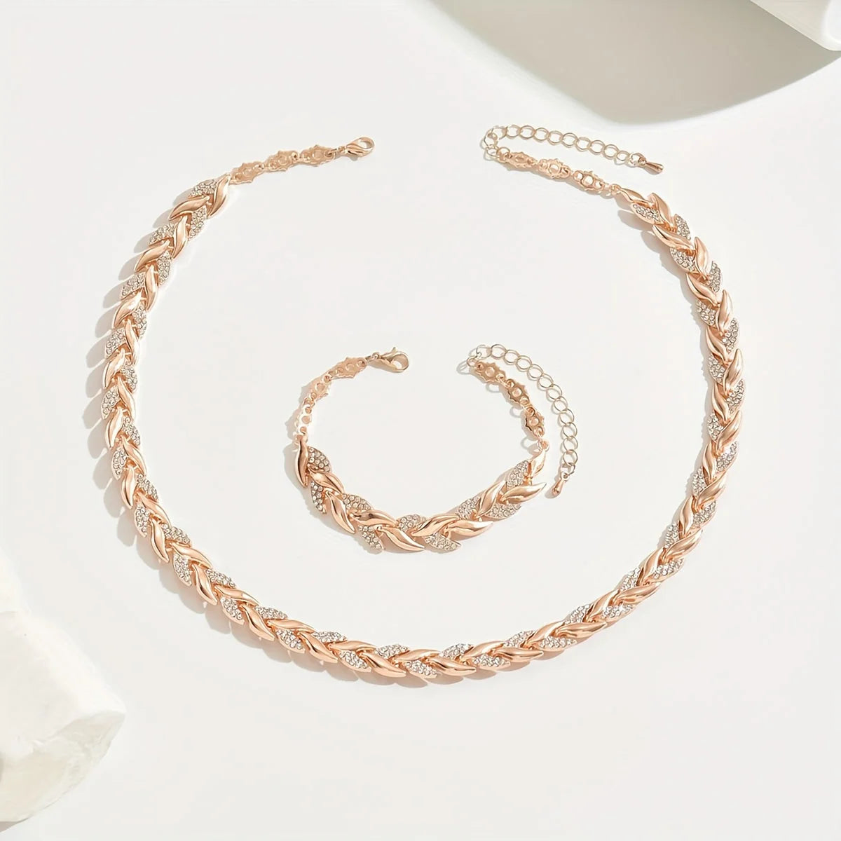 Overhead view of rhinestone chain necklace and bracelet set showing chevron link pattern
