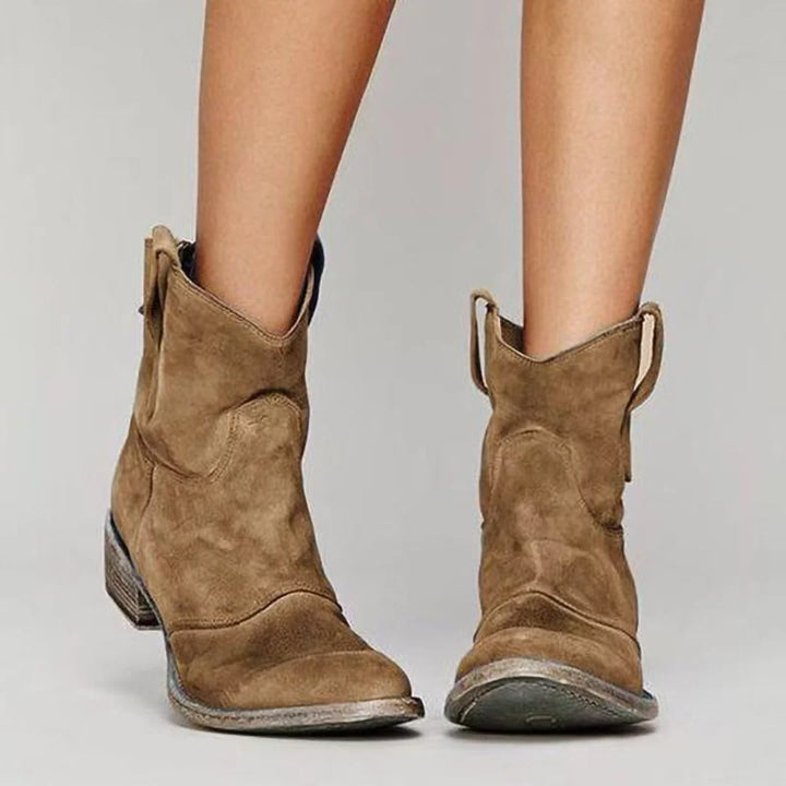 Close-up of women's western-style ankle boots showing rounded toe and suede-effect texture