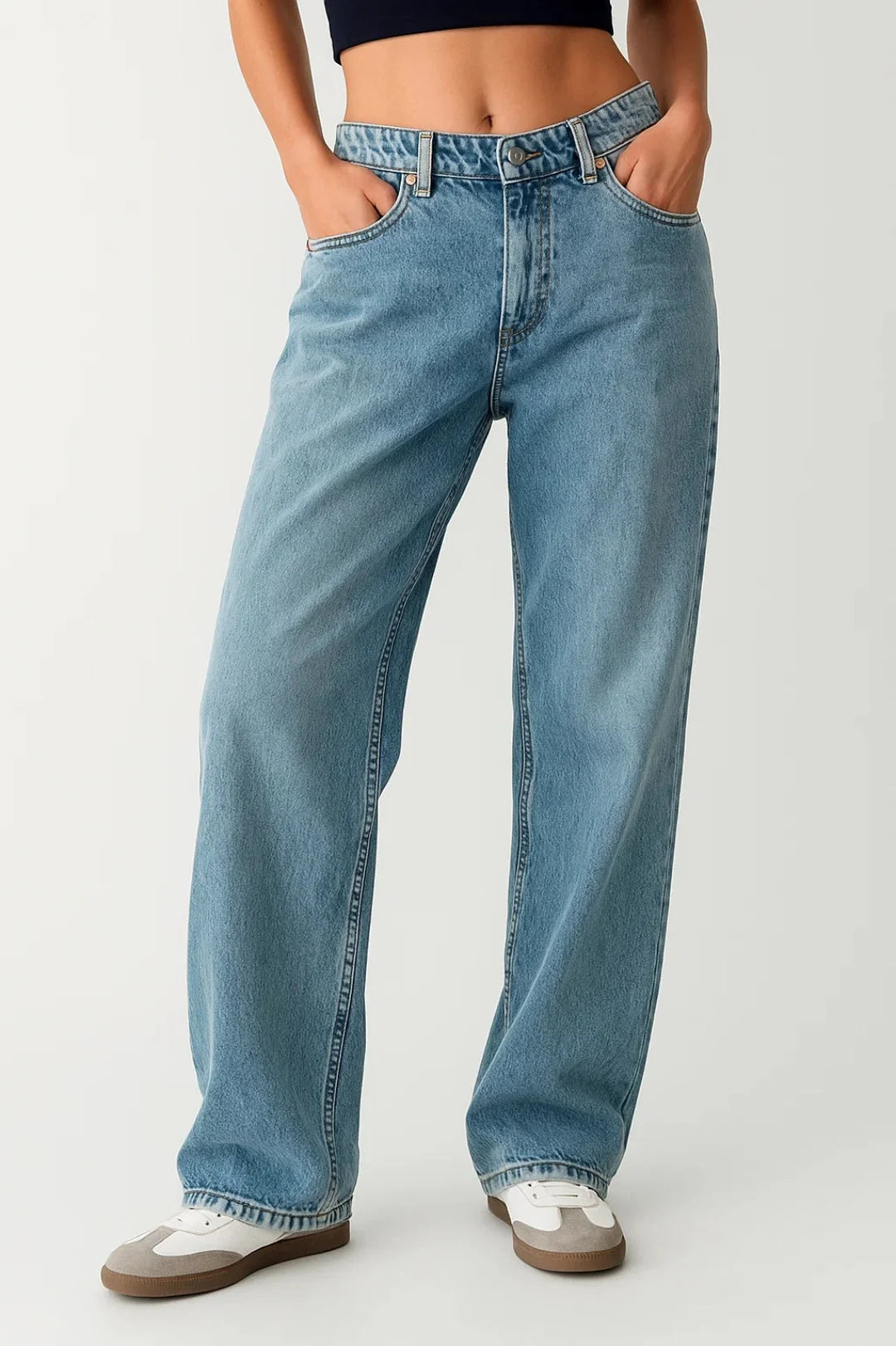 Women's baggy jeans in light wash denim with relaxed fit and straight legs styled with trainers