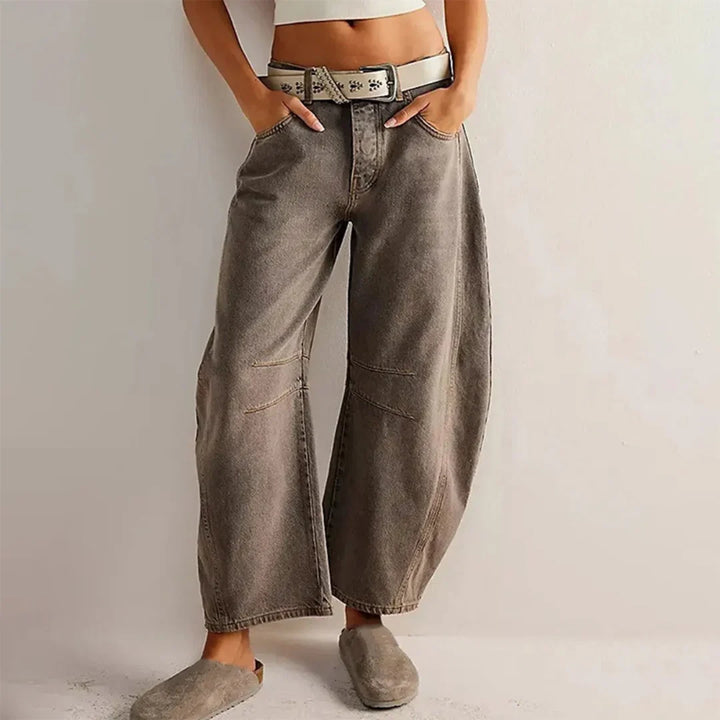 Full-length view of light blue barrel leg jeans with worn-in denim finish and modern silhouette