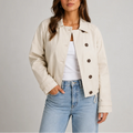 Women's cropped trench jacket in beige with classic collar and button front closure worn with jeans