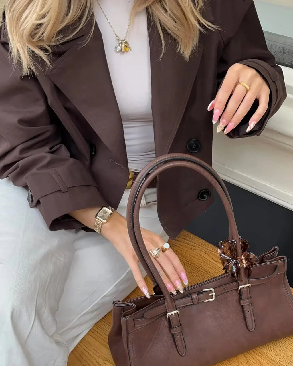 Detail of cuffed sleeves and epaulettes on women's cropped trench jacket