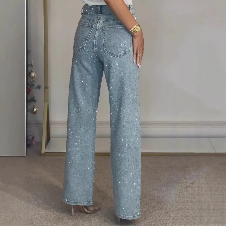 Side angle of high waisted embellished jeans with wide leg cut and allover diamanté detailing