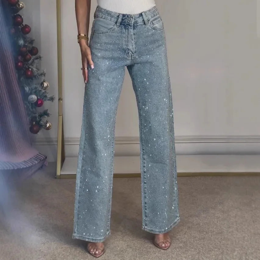 Full length view of women's embellished wide leg jeans paired with white ribbed top and heeled sandals