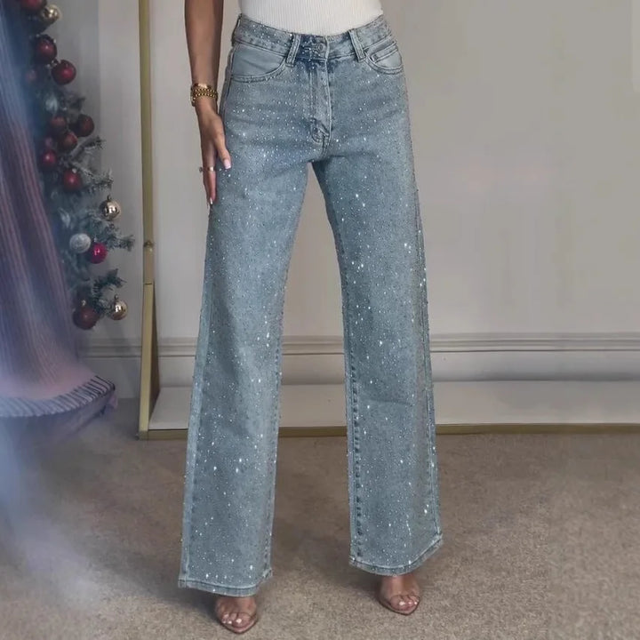 Full length view of women's embellished wide leg jeans paired with white ribbed top and heeled sandals