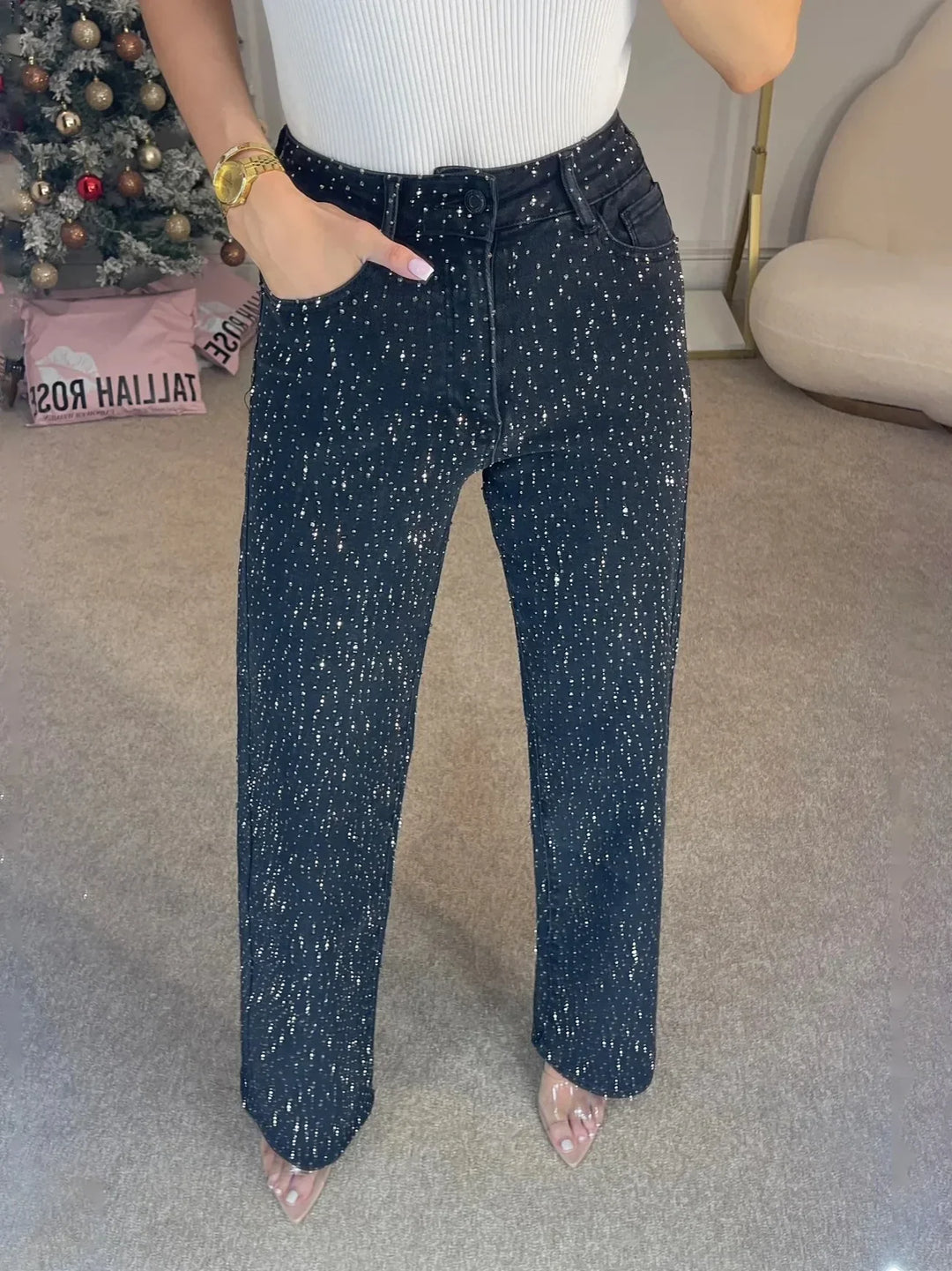 Styling shot of embellished wide leg jeans worn with fitted top for evening occasion outfit
