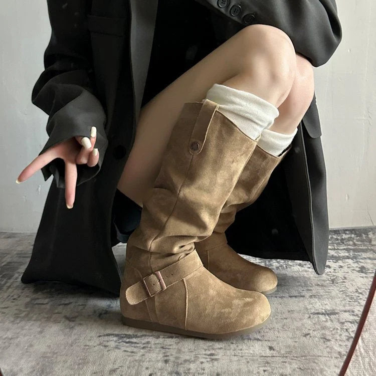 Close-up of knee-high slouch boot showing adjustable buckle strap detail at ankle