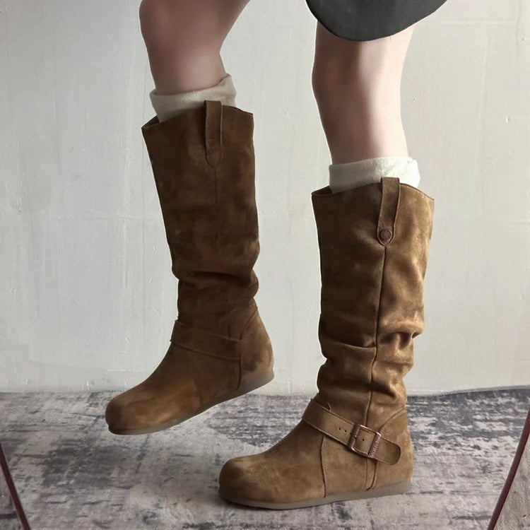 Full-length view of women's knee-high slouch boots in tan showing flat sole and relaxed silhouette
