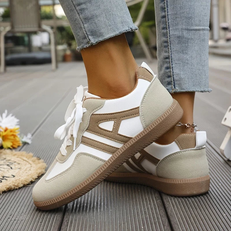 Close-up of women's wide-toe trainers showing two-tone colourway and ribbon lace detail