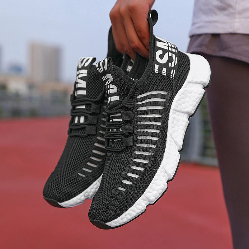 Men's knit trainers with cushioned sole and black rubber outsole on track surface