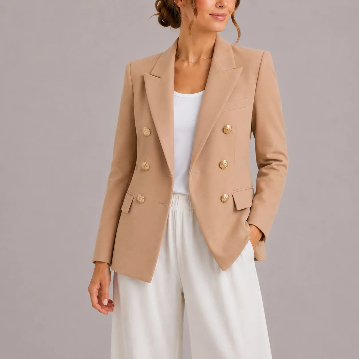 Close-up of double-breasted blazer gold button detailing and lapel construction
