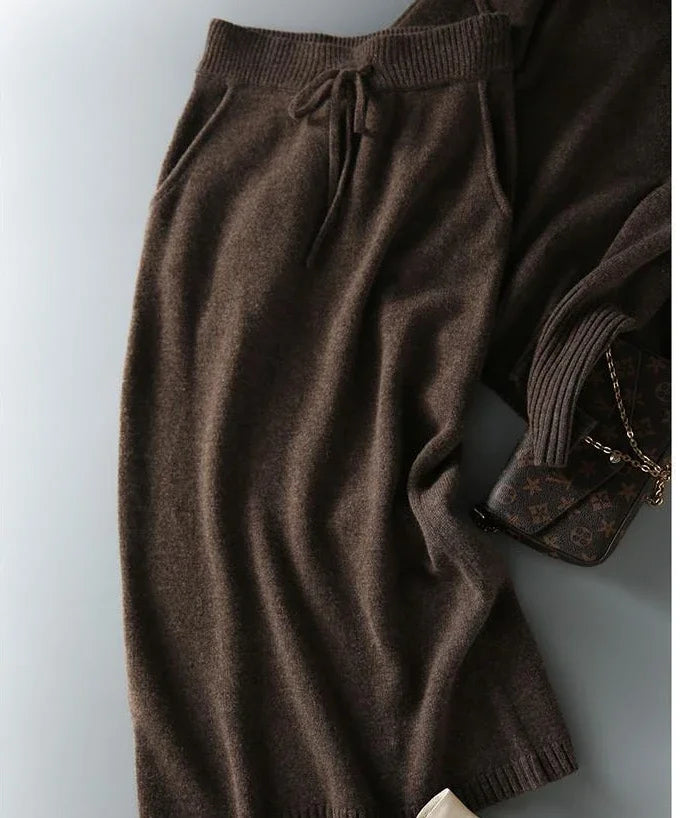 Women's taupe knitted set displayed showing coordinated jumper and skirt design