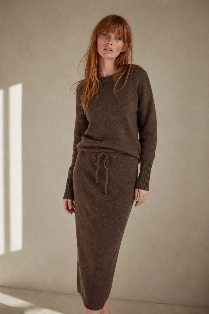 Close-up of ribbed crew neckline and structured knit fabric on taupe jumper