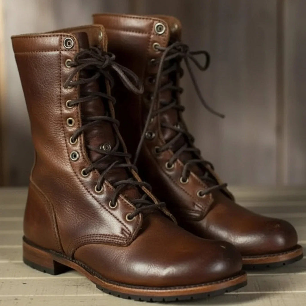 Women's lace-up mid-calf boots in brown with metal eyelets and flat sole on wooden floor