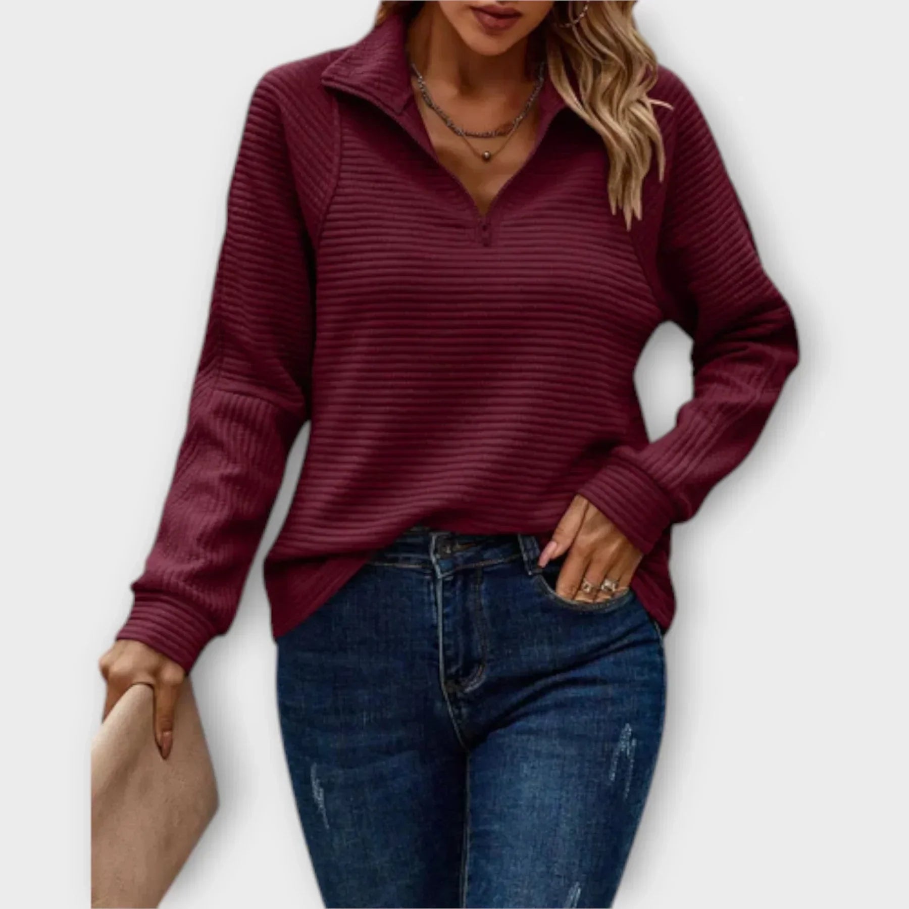 Detail of V-neck collar and zip hardware on women's ribbed half-zip jumper
