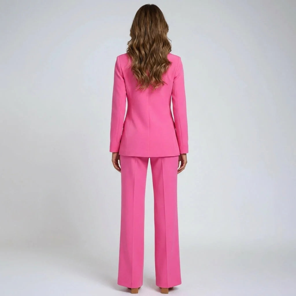 Detail of pink blazer with single-button closure, notch lapel, and structured shoulder line paired with matching trousers