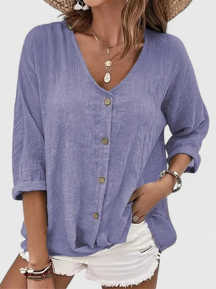 Close-up view of women's lightweight button-front blouse showing textured woven fabric and v-neckline detail