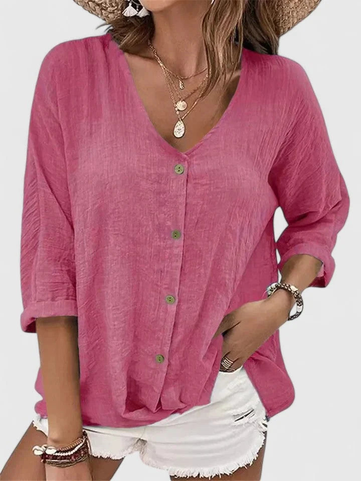 Side angle of relaxed-fit v-neck blouse with three-quarter sleeves and hip-length hem in blue shade
