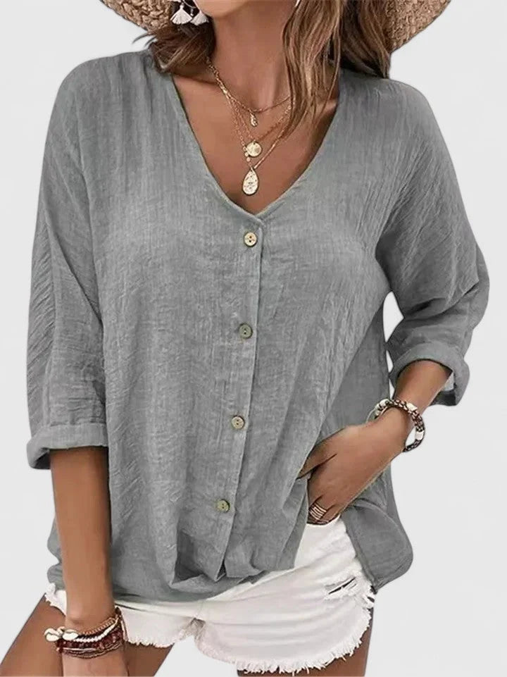 Women's casual button-up blouse styled with white denim shorts and gold jewellery for summer outings