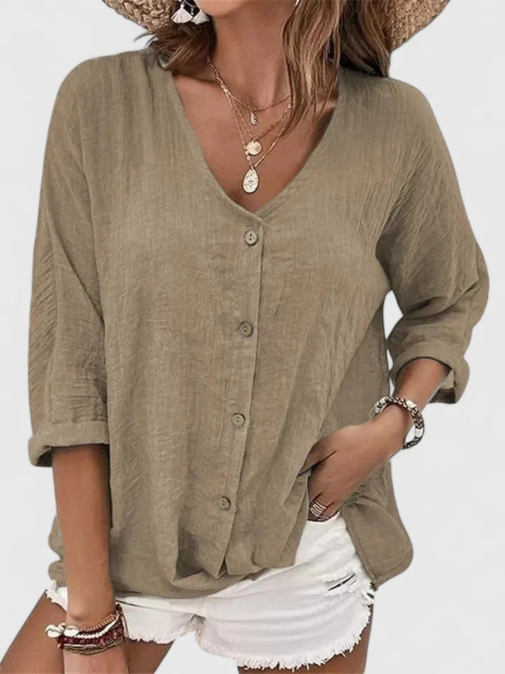 Detail of v-neck blouse button closure and soft drape fabric in lightweight woven material