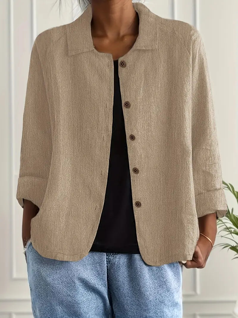 Side view of women's relaxed fit button-front shirt with rolled cuffs and hip-length hem