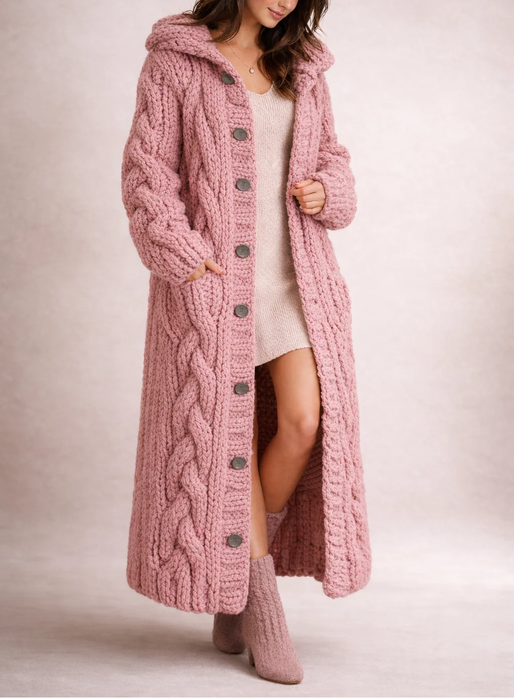 Full-length cable knit hooded cardigan styled over a knit dress with relaxed oversized fit