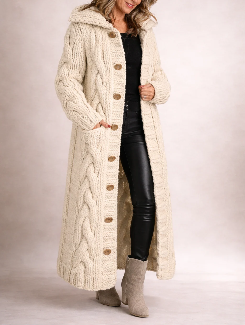 Close-up of chunky cable knit texture and button detail on women's long cardigan