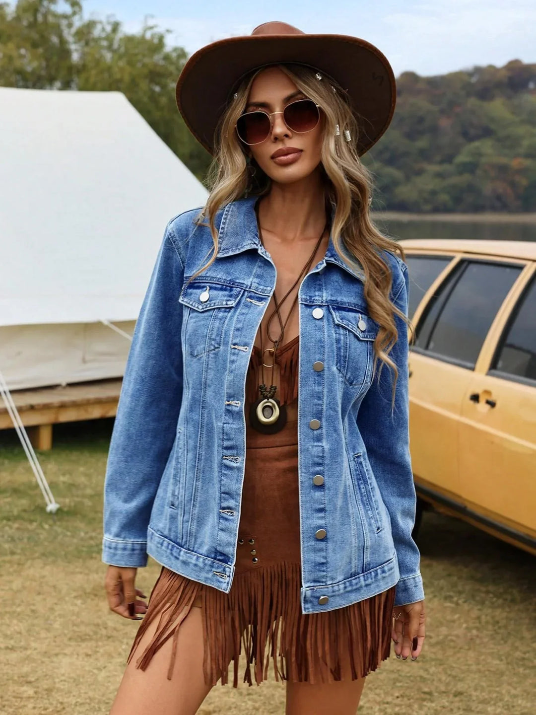 Women's denim jacket with button-front closure and chest pockets styled over a brown top outdoors