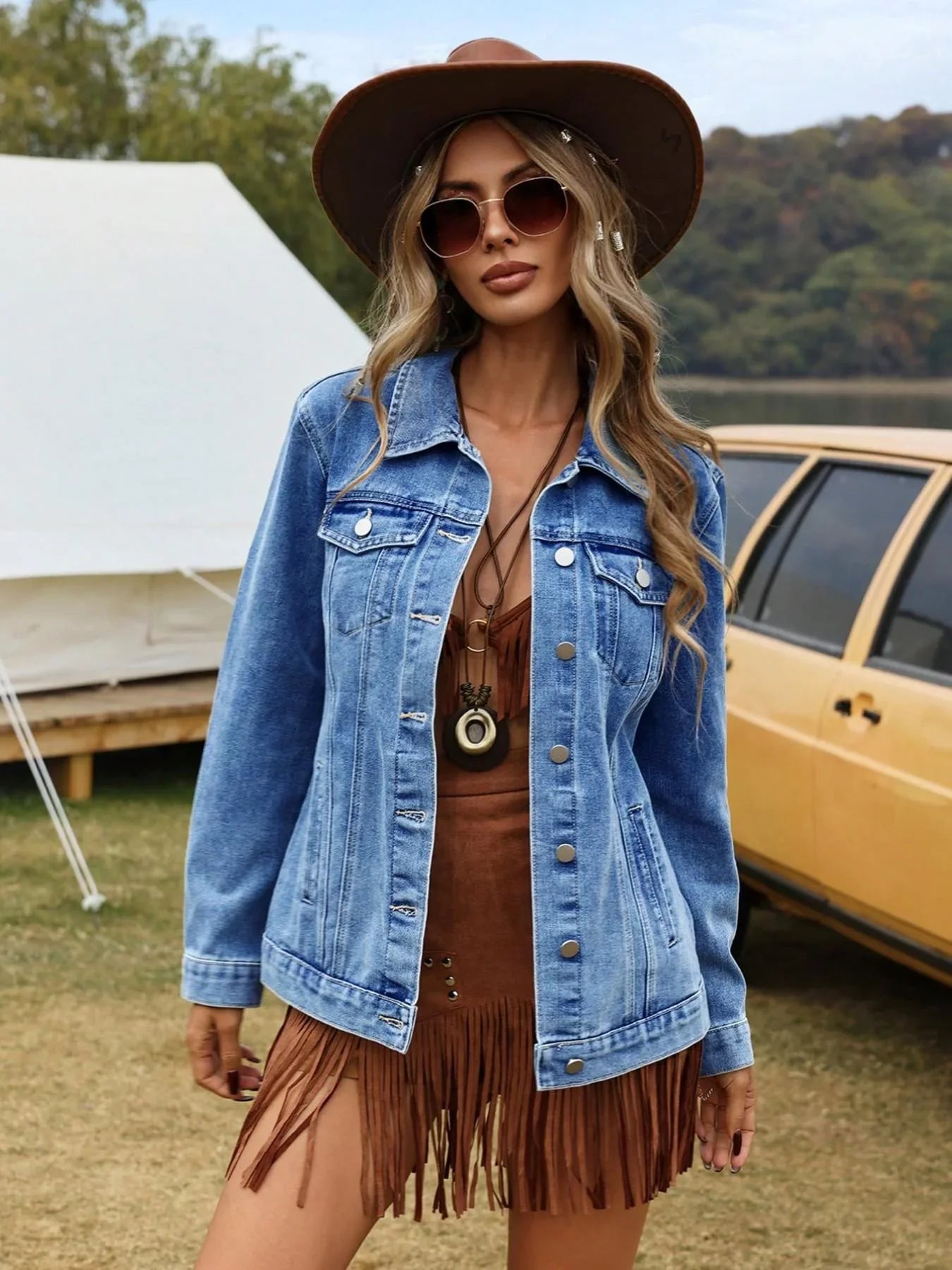 Women's denim jacket with button-front closure and chest pockets styled over a brown top outdoors