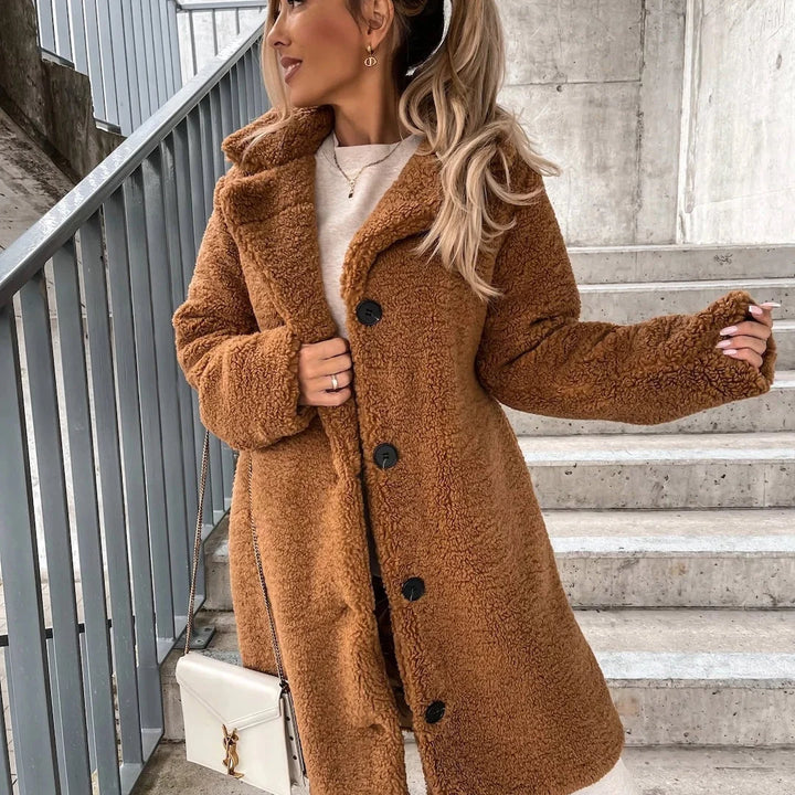 Close-up view of the fluffy teddy texture and patch pockets on a women's oversized coat
