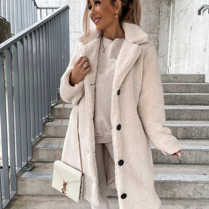 Side view of a mid-length teddy coat showing the relaxed oversized silhouette and dropped shoulders