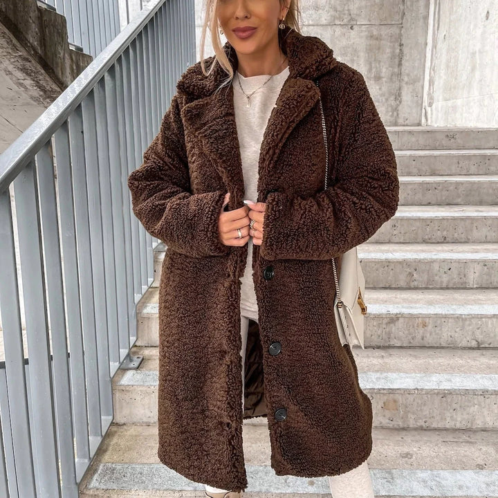 Detail of the button-front closure and notched collar on a women's teddy coat in beige
