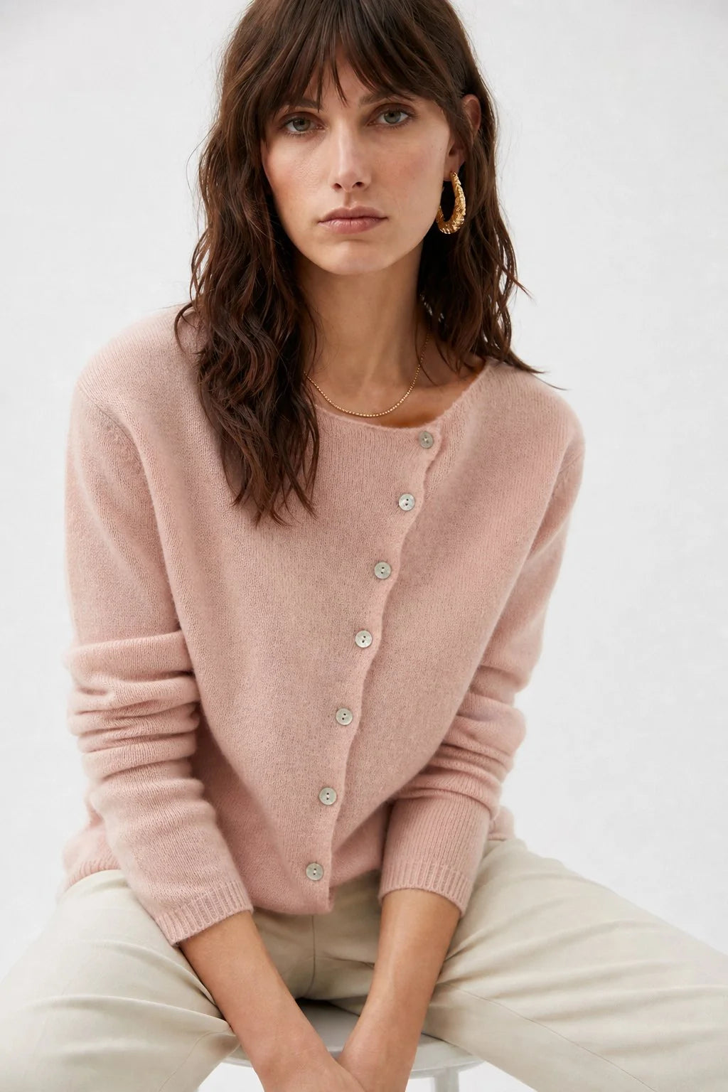 Detail of the shoulder seam and asymmetric button placement on a cashmere cardigan