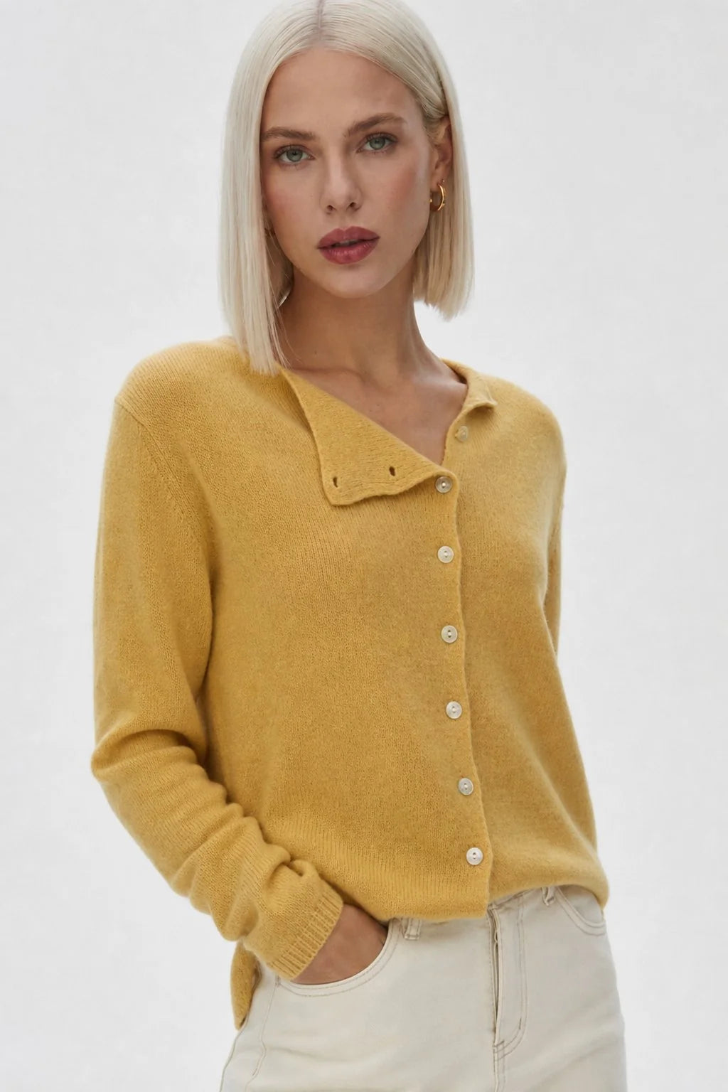 Back view highlighting the even hem and soft knit construction of a beige cardigan