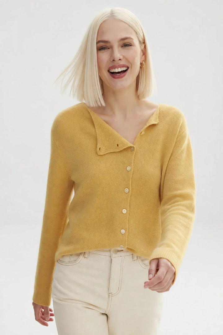 Close-up of the round neckline and button detail on a women's cashmere knit cardigan