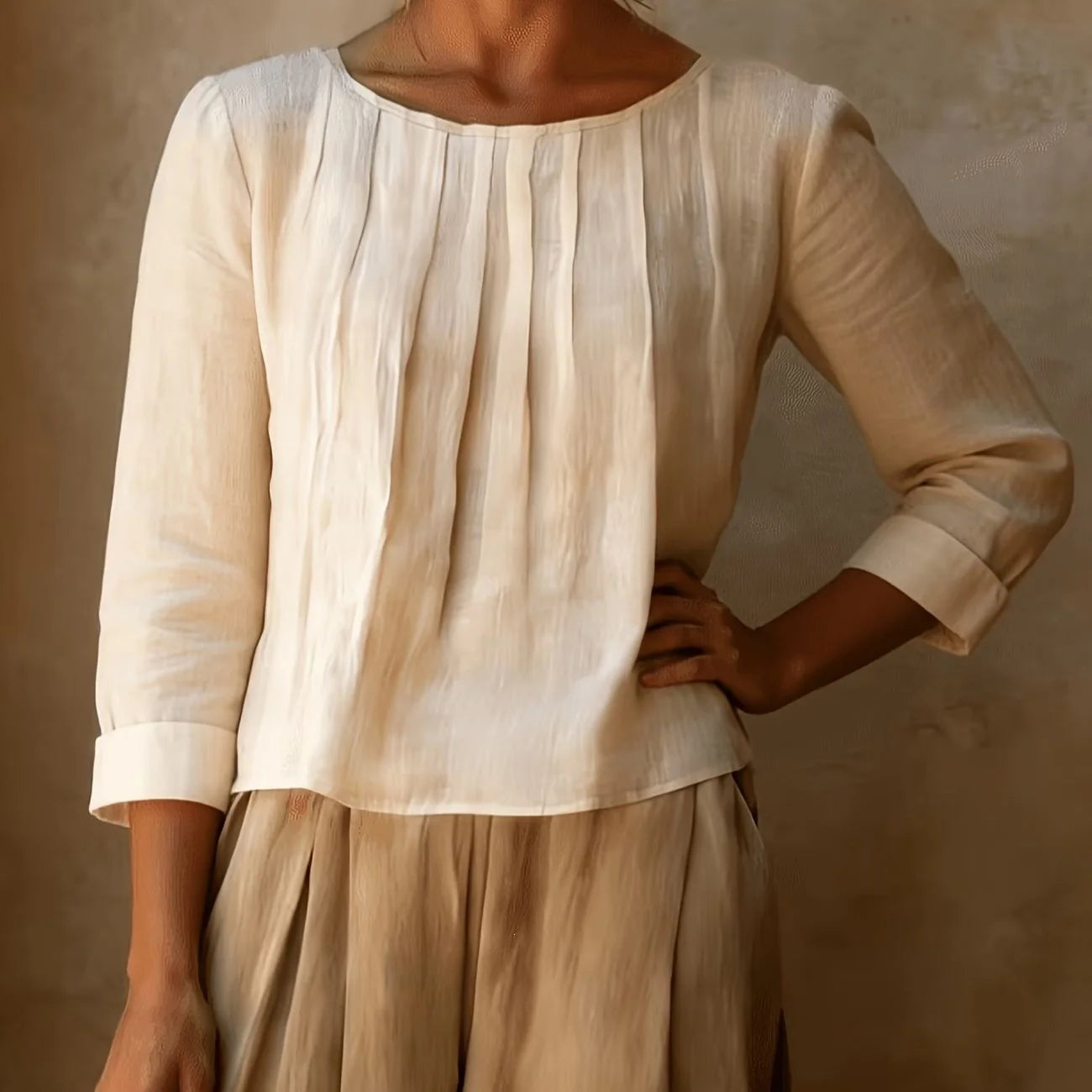 Women's pleated blouse with three quarter sleeves and round neckline in cream woven fabric with vertical pleats