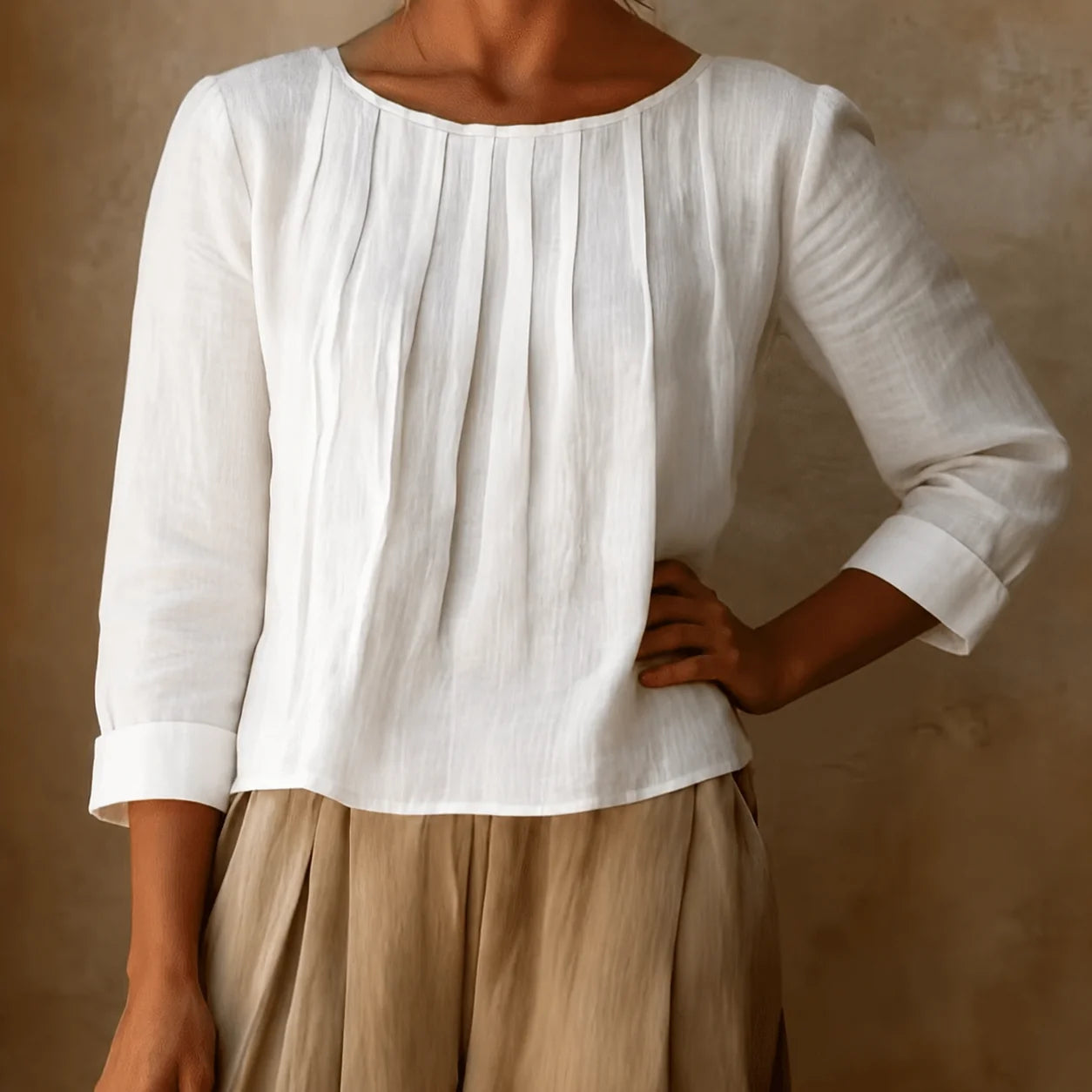 Back view of women's pleated blouse with three quarter sleeves and regular length falling at hip