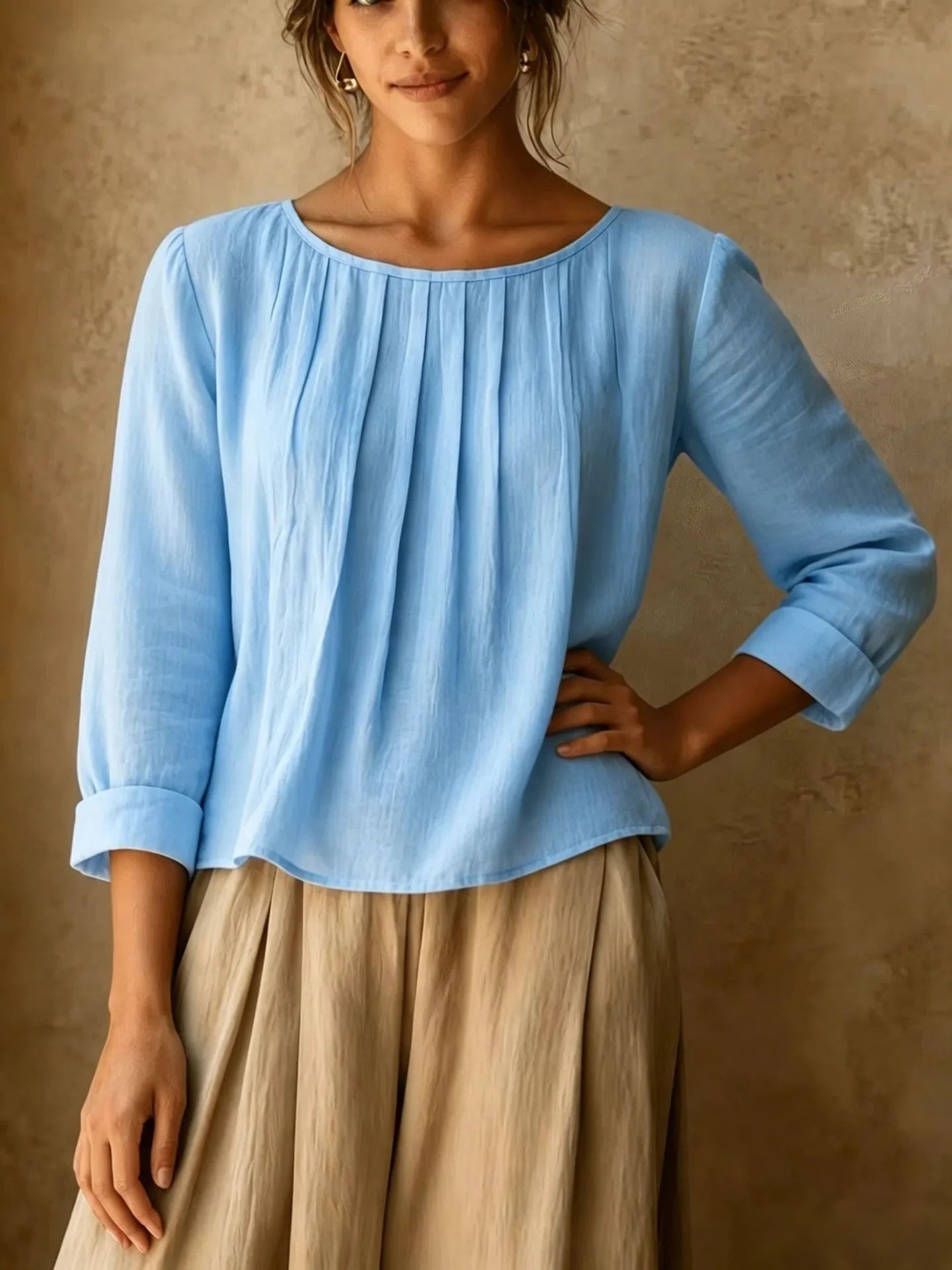 Full front view of women's pleated blouse with three quarter sleeves and round neckline in relaxed fit