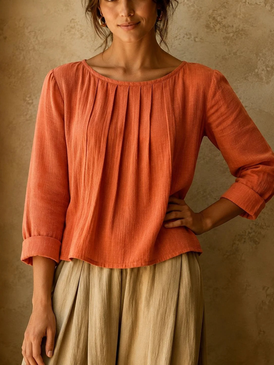 Women's pleated blouse styled with neutral bottoms showing versatile casual look and breathable woven fabric