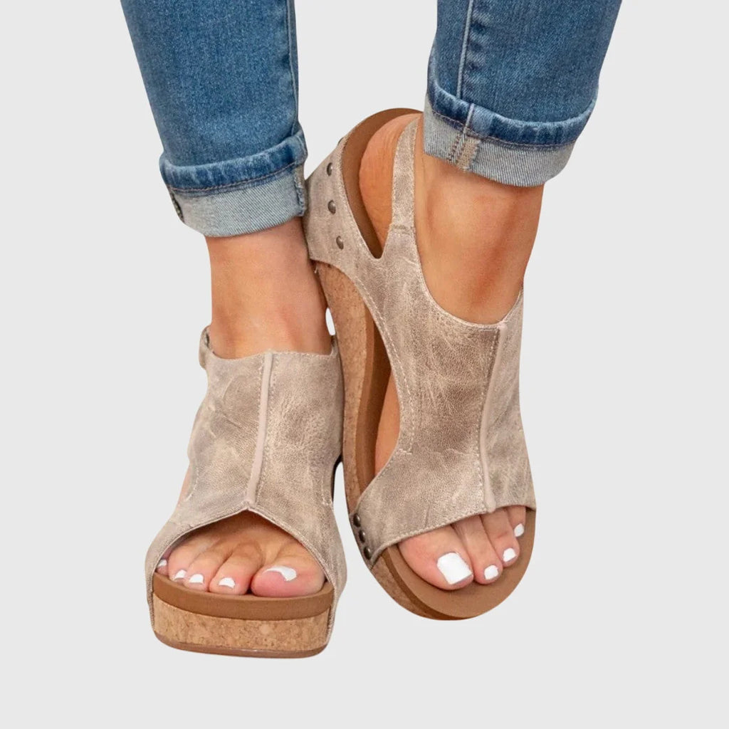 Close-up view of women's wedge sandals showing adjustable buckle strap and open-toe design